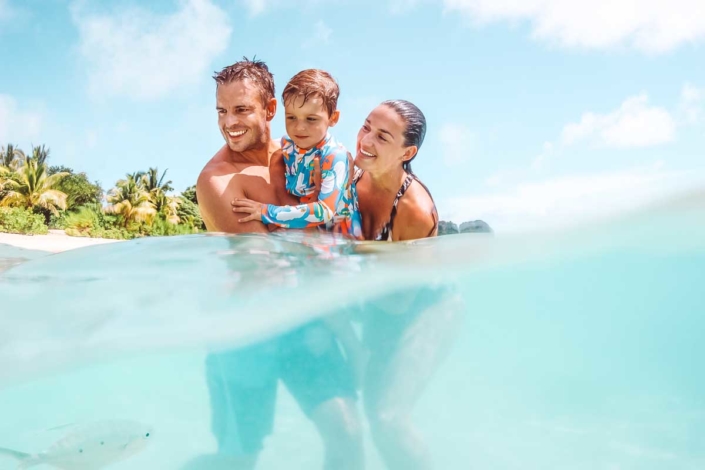 Family swimming in clear water offshore at vomo island fiji